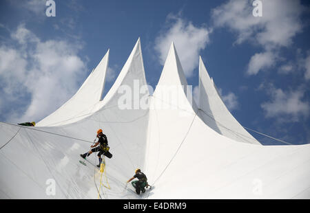 Berlino, Germania. 09 Luglio, 2014. Facciata scalatori pulire il tetto della sede evento Tempodrom di Berlino, Germania, 09 luglio 2014. La posizione ha la forma di una tenda del circo ed è stato riaperto come nuovo Tempodrom nel 2001. Foto: Kay Nietfeld/dpa/Alamy Live News Foto Stock