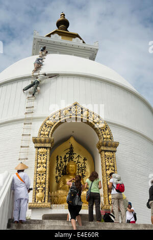 Il Nepal, Pokhara, Ananada Hill, Shanti Stupa, uomini della pittura la pace mondiale Pagoda white Foto Stock