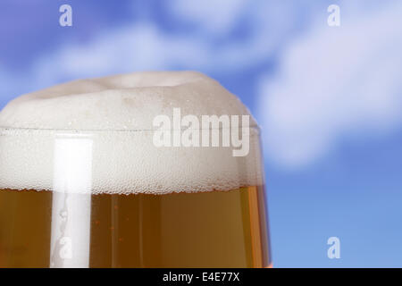 La birra in un bicchiere in beergarden davanti a un cielo blu Foto Stock