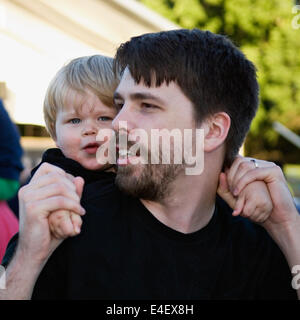 Padre con il figlio di due anni sulle spalle Foto Stock
