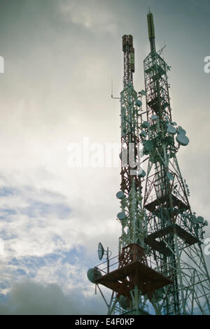 La torre delle comunicazioni contro blu cielo nuvoloso. Foto Stock