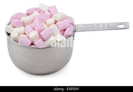 Rosa e Bianco mini marshmallows in una coppa America di misurare, isolato su sfondo bianco Foto Stock