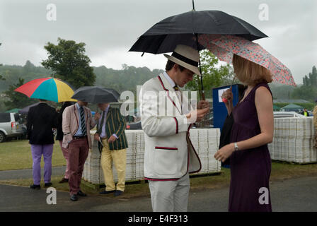 Uomo imbarazzato in cerca di un biglietto smarrito per entrare nello Stewards Enclosure alla Henley Royal Regatta. Pioggia tempesta estate britannica maltempo. Henley on Thames, Oxfordshire, Inghilterra, 2014, 2010s HOMER SYKES Foto Stock