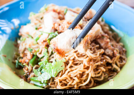 Close up croccante maiale azienda da chopstick Foto Stock