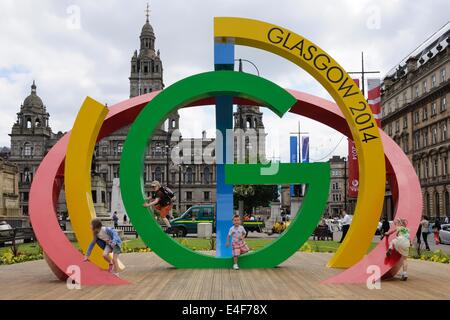 I bambini giocano sul Glasgow 2014 giochi del Commonwealth logo in George Square Foto Stock