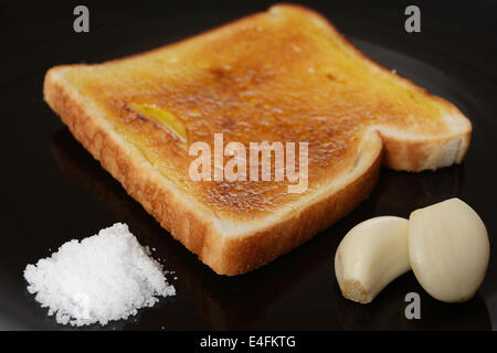 Dieta mediterranea della prima colazione con toast di pane, aglio, sale e olio di oliva. Foto Stock