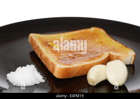 Dieta mediterranea della prima colazione con toast di pane, aglio, sale e olio di oliva. Foto Stock