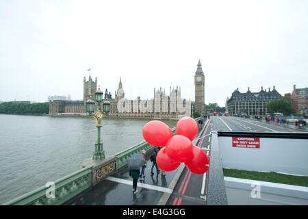 Westminster, Londra, Regno Unito. Il 10 luglio 2014. I pedoni a piedi sul Westminster Bridge con ombrelloni su un wet Rainy day in London Credit: amer ghazzal/Alamy Live News Foto Stock