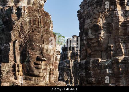 Antico in pietra facce del tempio Bayon, Angkor, Cambogia Foto Stock
