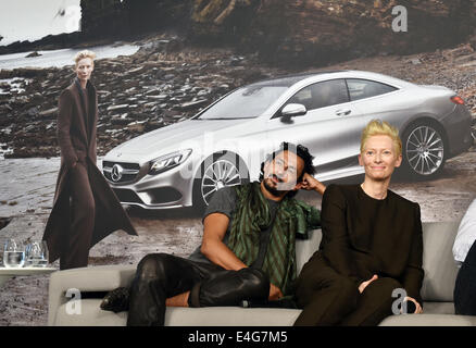 Berlino, Germania. 10 Luglio, 2014. Nato colombiano designer di moda Haider Ackermann e attrice britannica e vincitore di un Oscar Tilda Swinton pongono durante la presentazione del nuovo Mercedes-Benz campagna di moda davanti ad un'immagine dell'attrice a Berlino, Germania, 10 luglio 2014. Le collezioni Primavera/Estate 2015 vengono presentati alla settimana della moda di Berlino. Foto: Jens KALAENE/dpa/Alamy Live News Foto Stock