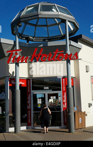 Donna inserendo un Tim Hortons caffetteria e ristorante in Vancouver, BC, Canada Foto Stock