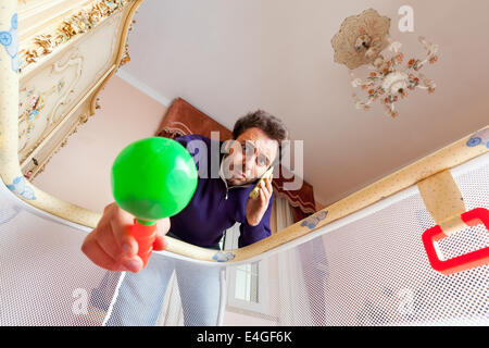 Disperata giovane padre mentre parlano al telefono. Foto Stock