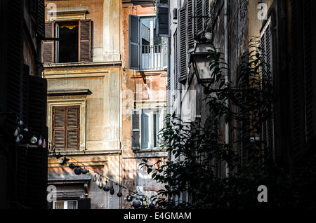 Strada stretta a Roma con luminoso edificio Foto Stock