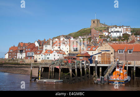 Vista del porto di Whitby, mostrando la scialuppa di salvataggio, della città e della Chiesa sulla collina. Foto Stock