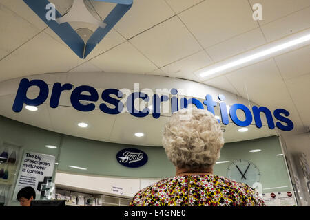 Una donna matura in attesa contatore di prescrizione in un scarponi. Foto Stock