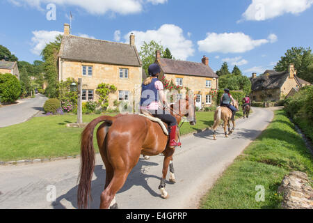 Equitazione nel villaggio Costwold di Stanton, Gloucestershire, England, Regno Unito Foto Stock