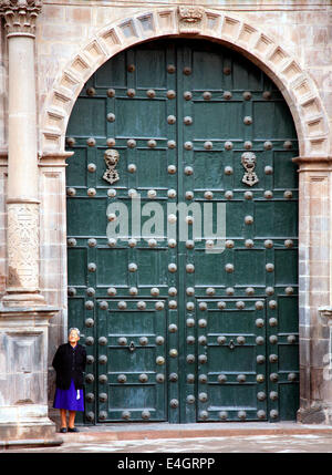 Cusco Cusco Peru grande cattedrale verde porte con una suora o sorella in piedi fuori la parte anteriore. Campania de Gesù o Cattedrale dei Gesuiti Foto Stock