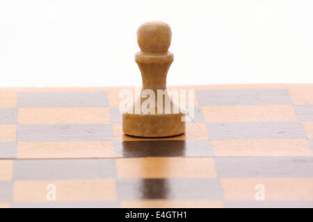 Pedina su una scacchiera di legno su bianco Foto Stock