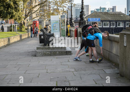 Per gli amanti del jogging corridori caldo verso il basso tratto su una corsa a casa dal lavoro per una serata primaverile, il fiume Tamigi, Lambeth, London REGNO UNITO Foto Stock