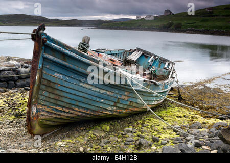 Weathered barca da pesca che giace su di una spiaggia rocciosa dell'isola di Lewis, Ebridi Esterne, Scozia Foto Stock
