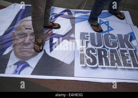 Di Giacarta, a Jakarta, Indonesia. 11 Luglio, 2014. Un banner di bandiera di Israele e il primo ministro è stato stampeded dal demonstrant . Migliaia di Moeslim da ogni elemento in Indonesia si sono riuniti presso Hotel Indonesia Rotatoria a protestare e a condannare la agression d'Israele Milliter a Gaza-Palestine che ha ucciso quasi 70 del popolo della Palestina la maggior parte sono donne e bambini. Credito: ZUMA Press, Inc./Alamy Live News Foto Stock