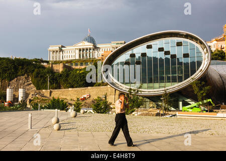 Nuovo teatro e sala espositiva a Rike Park e il palazzo presidenziale in background. Tbilisi, Georgia Foto Stock