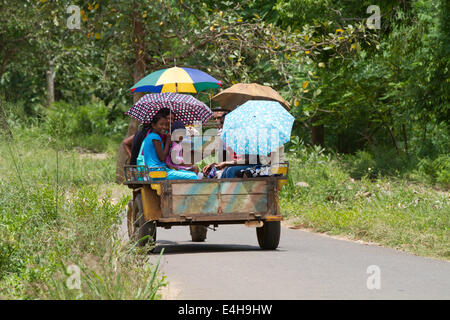 Gli abitanti di un villaggio di viaggiare nel retro di un trattore in prossimità di Anuradhapura, Sri Lanka sul modo per visitare la città durante il Wesak vacanza. Foto Stock