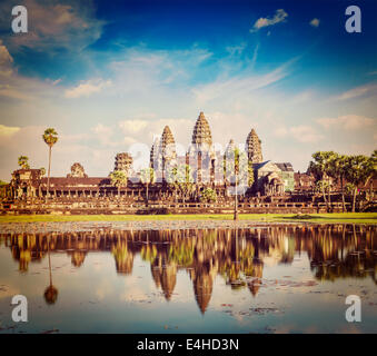 Vintage effetto retrò filtrata hipster stile immagine di viaggio di pietra miliare della Cambogia Angkor Wat con la riflessione in acqua Foto Stock