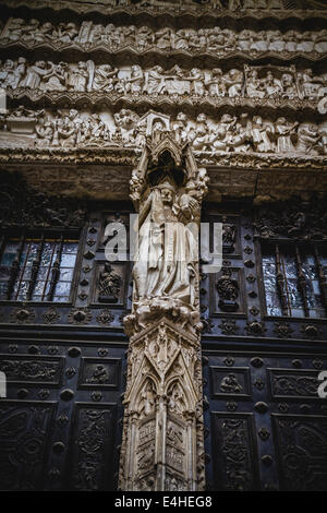 Ingresso laterale della Cattedrale di Toledo, ad arco con rilievi religiosi Foto Stock