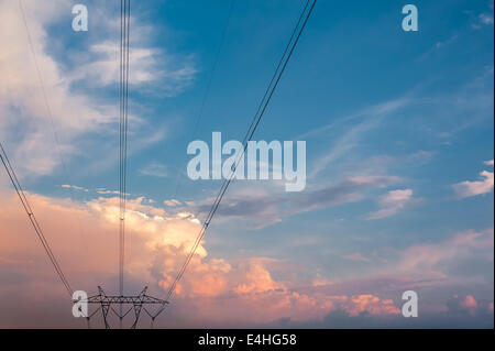 Le linee elettriche ad alta tensione convergono sotto belle nuvole soleggiato in Metro Atlanta, Georgia, Stati Uniti d'America. Foto Stock