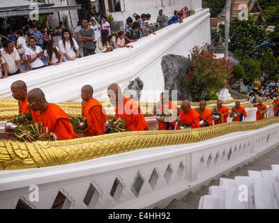 Phra Phutthabat, Saraburi, Thailandia. 12 Luglio, 2014. I monaci buddisti salire le scale per il Wat Phra Phuttabat durante il Tak Bat Dok mai in Saraburi provincia della Thailandia. Il Wat Phra Phutthabat è famosa per il modo in cui esso segna l inizio di Vassa, i tre mesi di ritiro annuale osservata dai monaci Theravada e monache. Il primo giorno di Vassa (o la Quaresima buddista) persone arrivano al tempio a ''make merito'' e presentare i monaci vi con dancing lady lo zenzero i fiori che fioriscono solo nelle settimane che precedono il Vassa. Credito: ZUMA Press, Inc./Alamy Live News Foto Stock