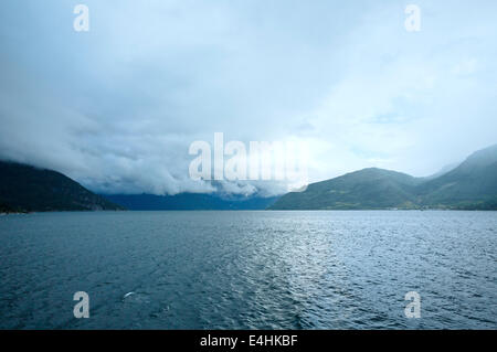 Hardangerfjord estate sera Nuvoloso vista dal traghetto (Norvegia) Foto Stock