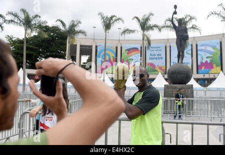 Rio de Janeiro, Brasile. 12 Luglio, 2014. Un tifoso di calcio pone con una copia della Coppa del mondo trofeo di fronte all'Estadio do Maracana di Rio de Janeiro, Brasile, 12 luglio 2014. Il Brasile dovrà affrontare nei Paesi Bassi il 12 luglio per il terzo posto nella Coppa del Mondo FIFA Brasile 2014 corrispondono al National Stadium di Brasilia. Foto: Thomas Eisenhuth/dpa/Alamy Live News Foto Stock