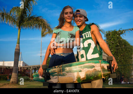 Gli amanti dei pattinatori di adolescenti in zona verde nella cinta Costera Oceano Pacifico circonvallazione costiera Bahia de Panama parco lineare seawall skylin Foto Stock