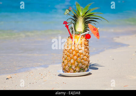 Cocktail di ananas sulla spiaggia di sabbia bianca Foto Stock