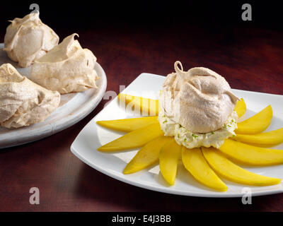 Muscavado meringhe con crema di calce e fette di mango Foto Stock