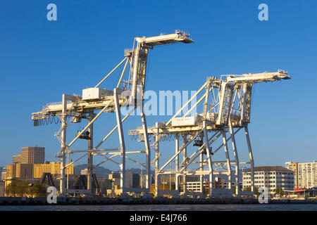 Tre container giganti gru incombente sull'acqua presso il porto di Oakland intermodale di container terminal Foto Stock