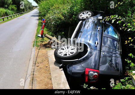 West Wittering, West Sussex, Regno Unito. 13 Luglio, 2014. Range Rover Freelander 2 supporti cordolo rompe attraverso il ponte di legno rotaie finisce in un piccolo ruscello presso la strada di accesso al West Wittering Parcheggio Auto. Le ambulanze sono state sulla scena. La causa non è noto o se eventuali danni subiti Fotografia Gary Blake/Alamy Live Live News Foto Stock