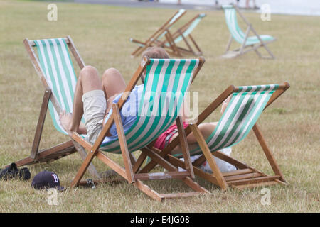 Kensington, London, Regno Unito. 13 Luglio, 2014. Le persone a rilassarsi nelle sedie a sdraio su una calda giornata in Hyde Park Londra in una calda giornata di tempo soleggiato Credito: amer ghazzal/Alamy Live News Foto Stock