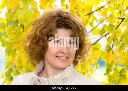 Donna di mezza età in autunno park Foto Stock
