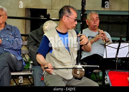 NYC: musicista cinese la riproduzione del Erhu, una chitarra, durante una performance in Chinatown la Columbia Park Foto Stock