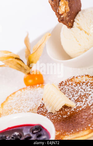 Gustose frittelle dolci con gelato alla vaniglia marmellata di frutta e sciroppi topping Foto Stock