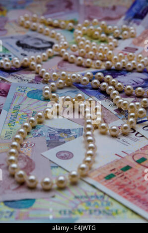 Filo di Perle giacente su British pound note Foto Stock