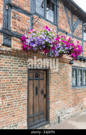 Costruito in mattoni, graticcio bungalow a schiera casa di città con cestini appesi e porta di legno a Henley-on-Thames, Oxfordshire, Regno Unito Foto Stock