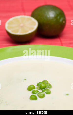 Piselli verdi in una zuppa cremosa con limoni Foto Stock