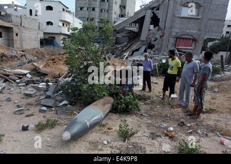 La città di Gaza, Striscia di Gaza, Territori palestinesi. 14 Luglio, 2014. Palestinesi guardare un missile che testimoni ha detto è stato sparato da un aereo israeliano, come stanno di fronte a una casa che polizia ha detto che era stato distrutto in un attacco aereo israeliano . Israele è apparso per tenere fuori su una minaccia di escalation del suo week-vecchio nella Striscia di Gaza barrage su lunedì nonostante balking presso la Western chiede un cessate il fuoco con un altrettanto indifferente Hamas. Credito: ZUMA Press, Inc./Alamy Live News Foto Stock