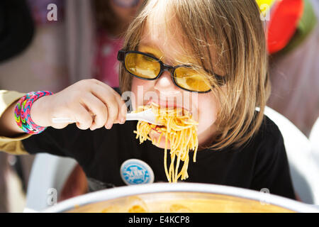 Soho, Londra, UK, 13 luglio 2014. La quarantesima edizione annuale di Soho Village Fete. Musica dal vivo, intrattenimenti e bancarelle. I bambini mangiare spaghetti contest. Spaghetti di mangiare i bambini. Foto Stock