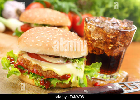 Hamburger fatti in casa con verdure fresche e formaggi sul tagliere di legno Foto Stock