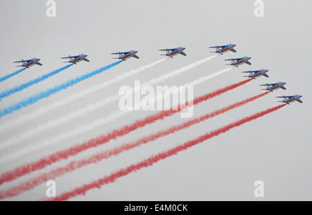 Parigi, Francia. 14 Luglio, 2014. La Patrouille de France di francese Air Force, rilasciando scie di blu, bianco e rosso di fumo, i colori della nazionale francese di bandiera, vola in formazione su Parigi durante l annuale per il giorno della Bastiglia parata militare, in Francia, il 14 luglio 2014. La Francia ha celebrato la Giornata Nazionale con un Grand Parade, che è stato partecipato da truppe provenienti da 80 nazioni. Credito: Li Genxing/Xinhua/Alamy Live News Foto Stock