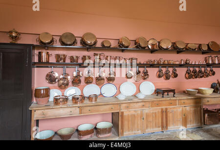 Utensili da cucina in rame lucido, pentole, padelle, pentole, tazze, cene bianche e piatti da pranzo appesi in mostra a Felbrigg Hall, Norfolk, Regno Unito Foto Stock